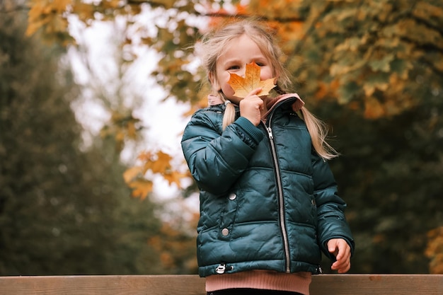 Niña en el parque de otoño