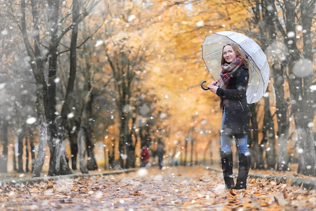 Una niña en el parque en un paseo en la primera nevada