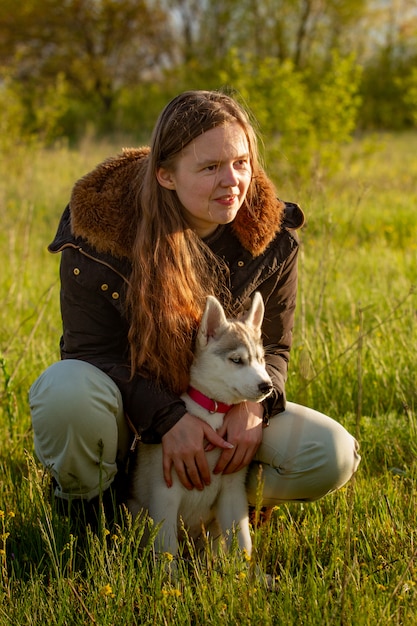 Niña en el parque de su casa con un cachorro Husky