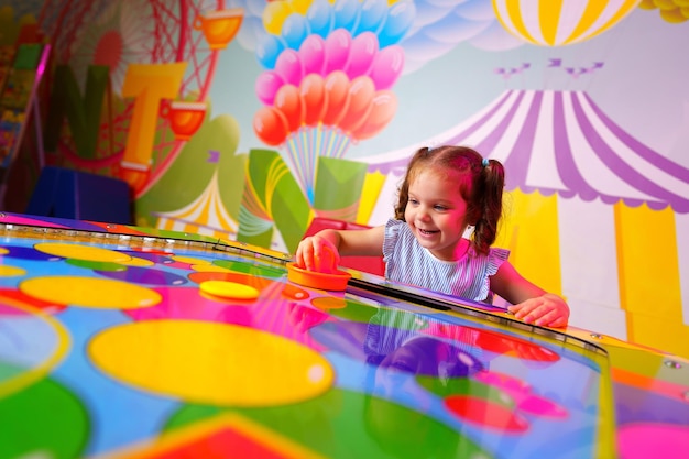 Foto una niña participando en un colorido juego de mesa en una sala de juegos vibrante