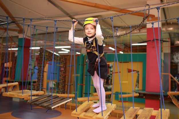 La niña pasa una carrera de obstáculos, un teleférico.