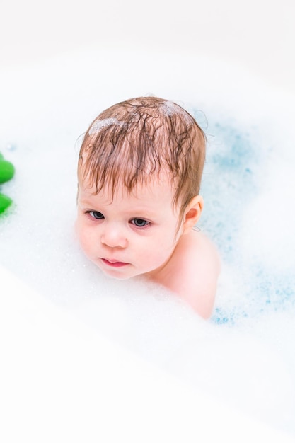 Niña pasándola bien durante la hora del baño.