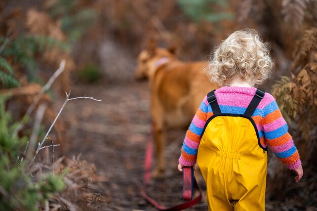 Una niña paseando a su perro con correa en un sendero de caminata en Alemania