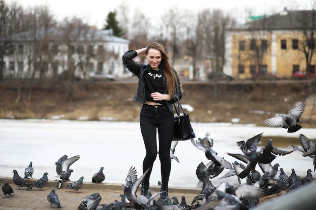 Una niña en un paseo por el parque y una bandada de palomas.