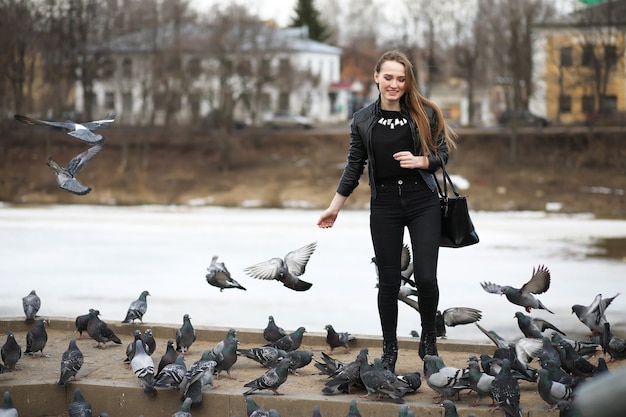 Una niña en un paseo por el parque y una bandada de palomas.