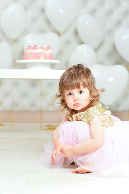 Niña con pastel en su cumpleaños posando en casa