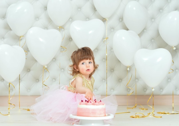 Niña con pastel en su cumpleaños posando en casa