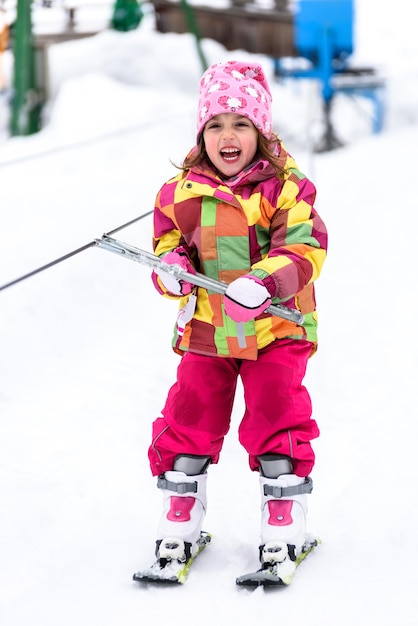 Niña patinando sobre hielo en la nieve