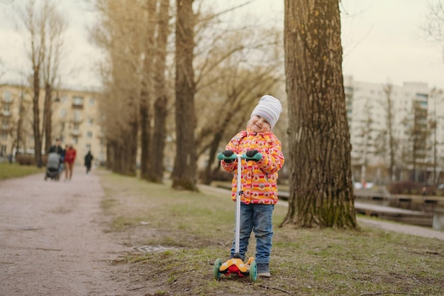 Niña con patinete en el parque