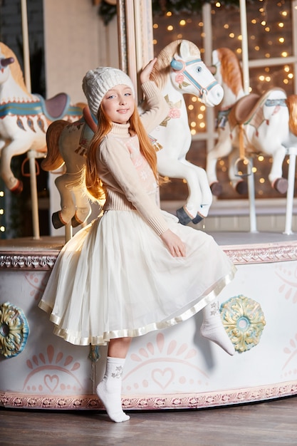 Niña pelirroja brillante en un sombrero blanco