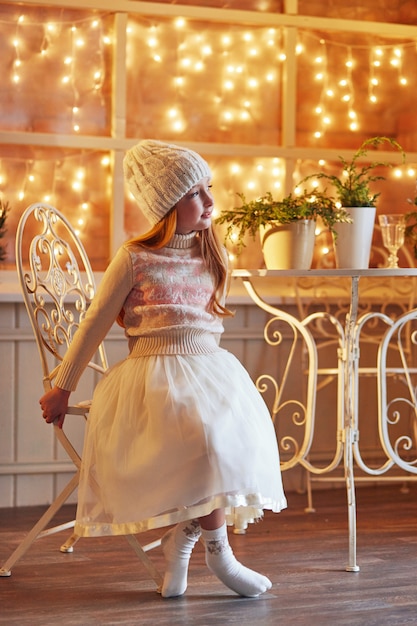 Niña pelirroja brillante en un sombrero blanco