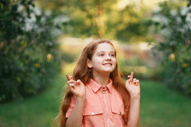 Niña pelirroja con dedos cruzados