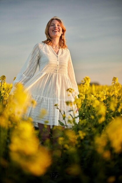 Foto niña pelirroja con vestido blanco en el campo de rap