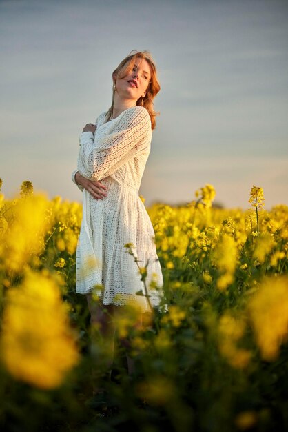 Foto niña pelirroja con vestido blanco en el campo de rap