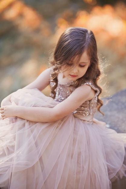 Niña con pelo largo en elegante vestido marrón