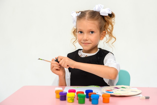 Niña pensativa dibuja en la escuela