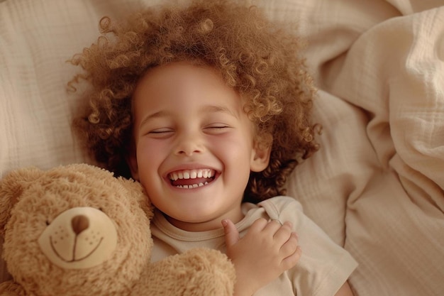 una niña pequeña acostada en la cama con un oso de peluche