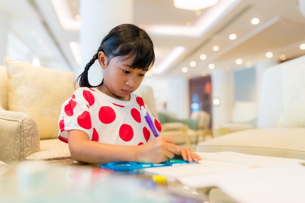 Niña pequeña dibujando en un libro