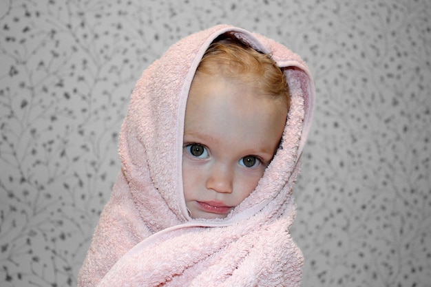 Foto una niña pequeña está envuelta en una toalla después de bañarse retrato en primer plano