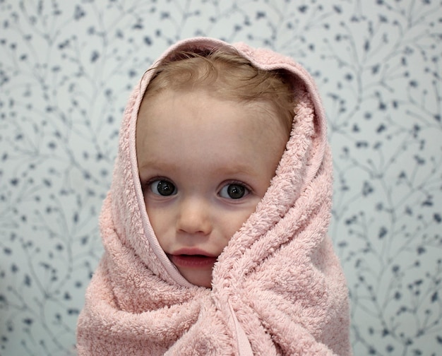 Una niña pequeña está envuelta en una toalla después de bañarse Retrato de primer plano