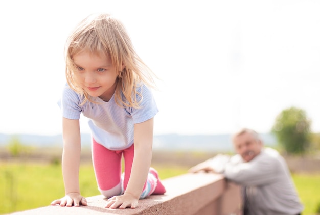 Una niña pequeña está jugando a gatear sobre sus rodillas a una altura