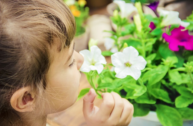 Una niña pequeña está plantando flores. El joven jardinero. Enfoque selectivo