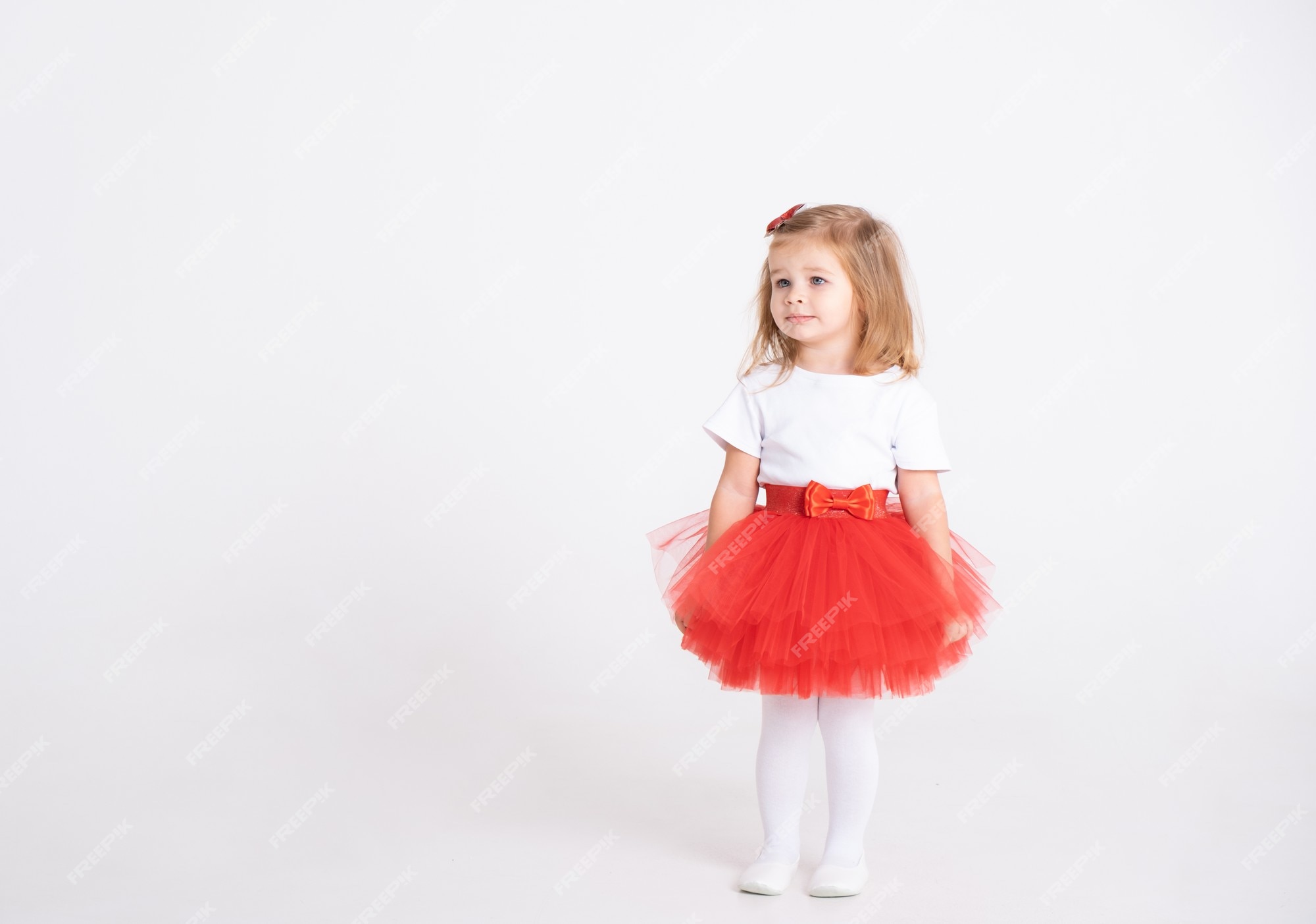 Niña pequeña en falda roja y camiseta blanca blanco. concepto de san valentín. | Foto Premium