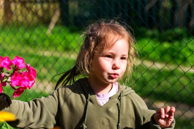 Niña pequeña y feliz sobre fondo de flores