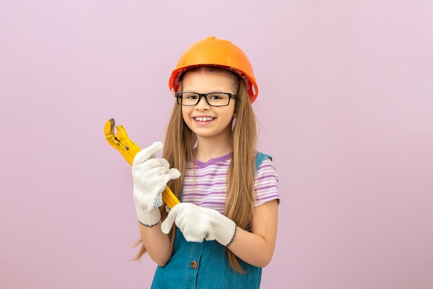 Una niña pequeña iba a hacer reparaciones en la casa. Un niño con un casco protector en la cabeza.