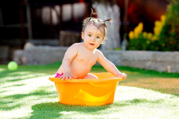 Niña pequeña jugando al aire libre con los juguetes