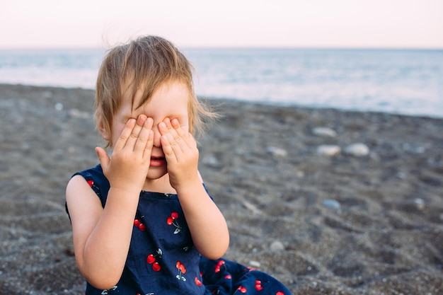 Niña pequeña y linda jugando en la orilla del mar en verano