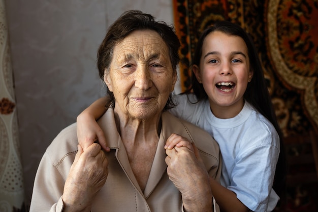 Niña pequeña y mujer muy mayor. Niño abrazando a la abuela. Nieta