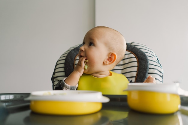 Foto niña pequeña con nutrición sólida niña comiendo comida y mezclando plato de verduras