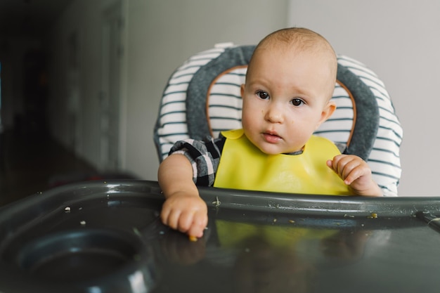 Niña pequeña con nutrición sólida niña comiendo comida y mezclando plato de verduras