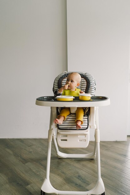 Niña pequeña con nutrición sólida niña comiendo comida y mezclando plato de verduras