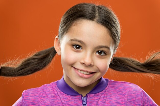 Foto niña pequeña peluquería para niños moda infantil y ropa deportiva felicidad infantil familia día del niño niño pequeño feliz niña feliz con el pelo largo mis pómulos en punto hoy