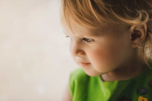 La niña pequeña se sienta en la habitación