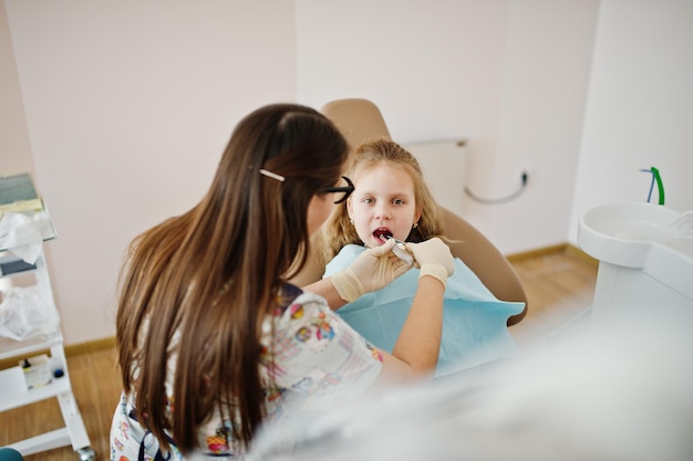 Niña pequeña en la silla del dentista