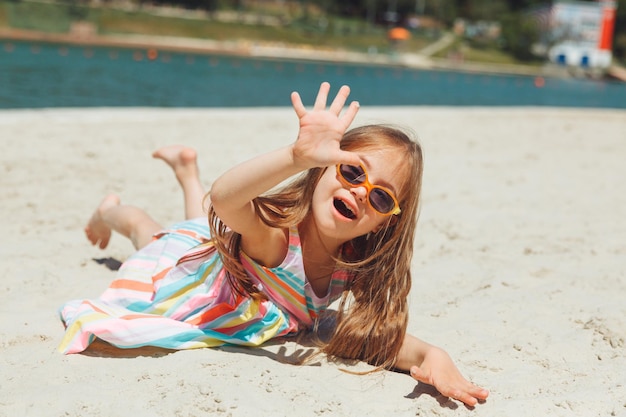 Niña pequeña con síndrome de down yace en la playa vida normal de los niños con síndrome de down