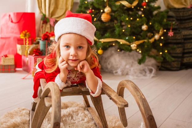 Niña pequeña con sombrero de navidad soñando con el milagro de navidad Niña pide un deseo una noche de año nuevo