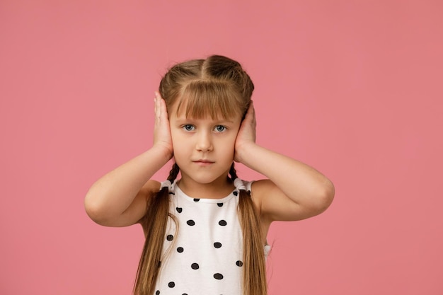 Niña pequeña tapándose la oreja con la mano