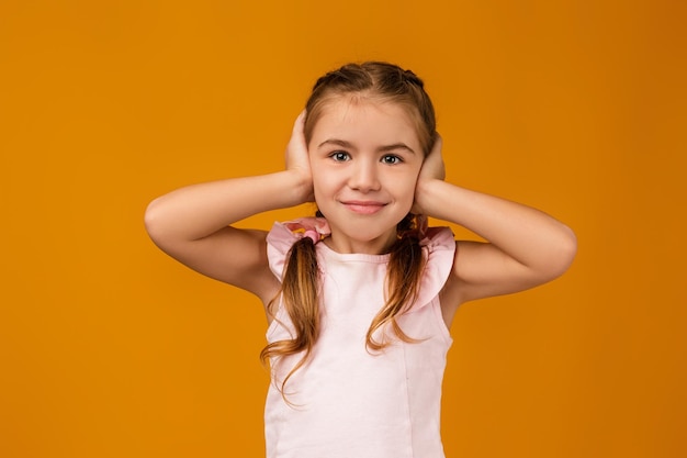 Niña pequeña tapándose la oreja con la mano