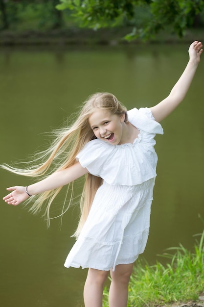 Niña pequeña en vestido blanco al aire libre