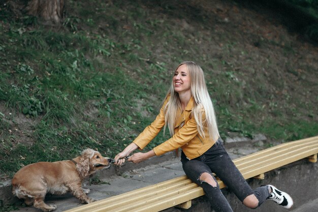 Niña con perro camina en el parque