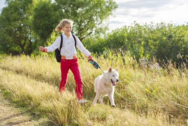 niña con perro caminando en la naturaleza