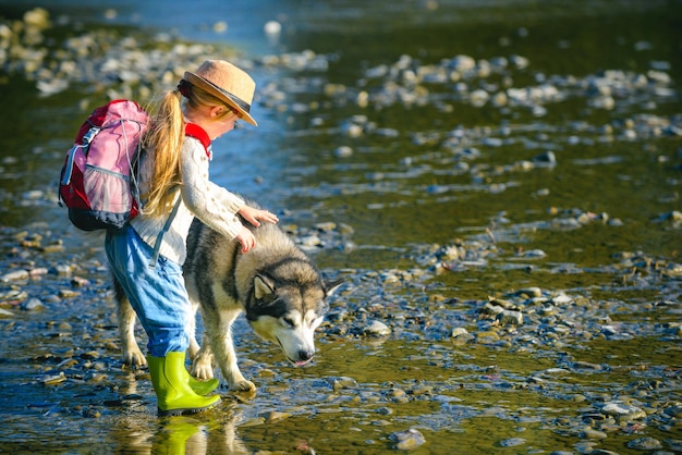 Niña con perro caminando en el río niños y perro explorando niños turistas y perro en be