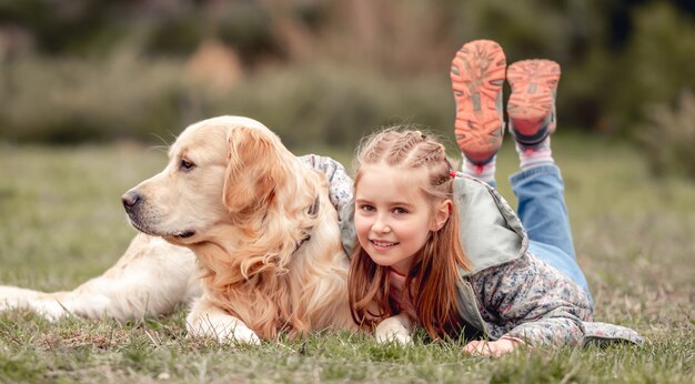 Niña con perro golden retriever fuera