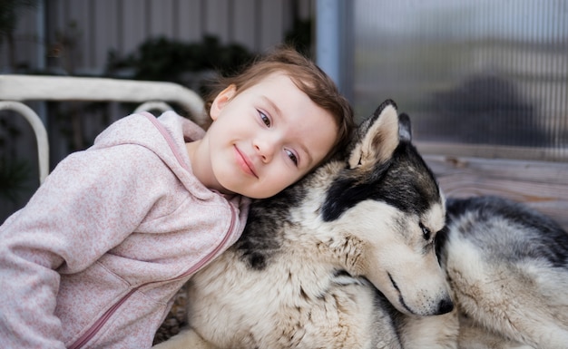 Niña con un perro husky