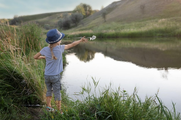 Una niña pescadora atrapó un pez y lo devolvió al lago.