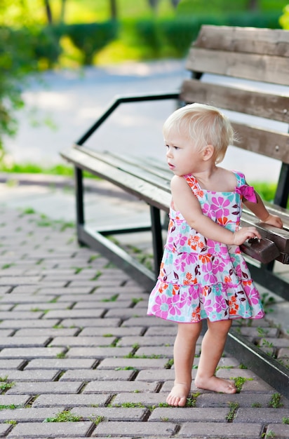 Niña de pie cerca del banco